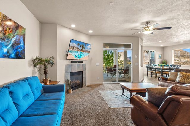 Living area with blue sofa, fireplace and patio doors beyond