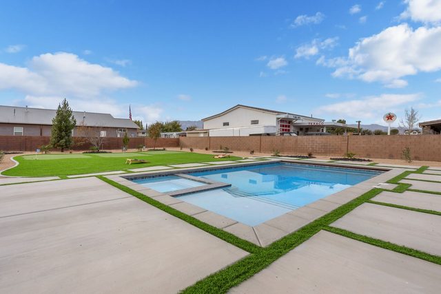 Private pool with attached spa and turf lawn beyond