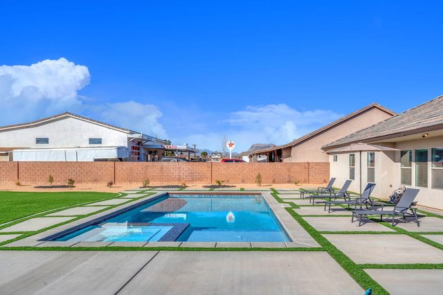 Private pool and spa with lounge chairs along the house