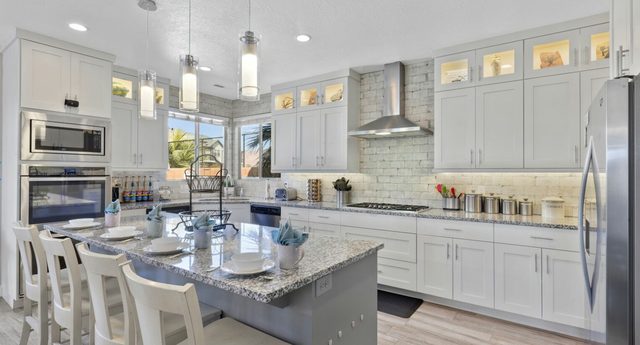 Home 107 kitchen with granite island, double ovens and bar seating