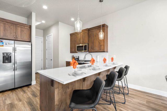Kitchen island with bar stools and stainless fridge