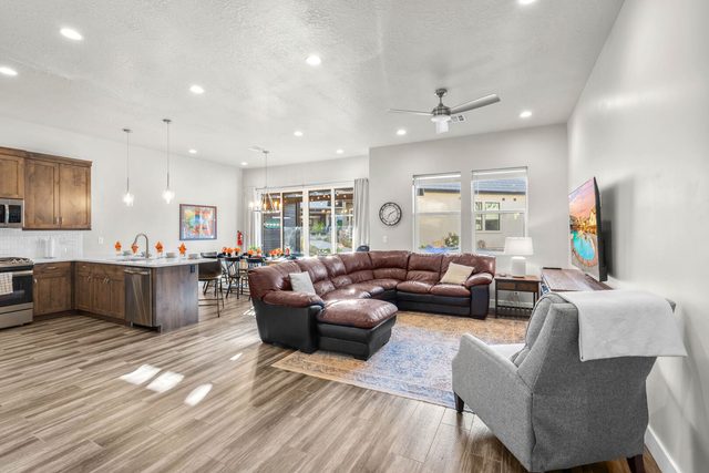 Open living room with leather sectional and kitchen beyond
