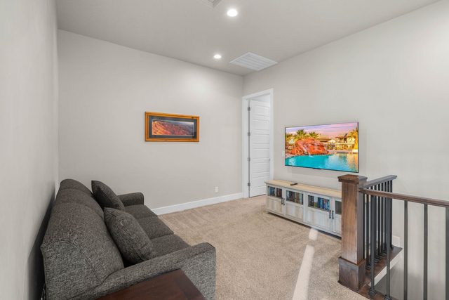 Upstairs loft with sofa, TV and stair railing