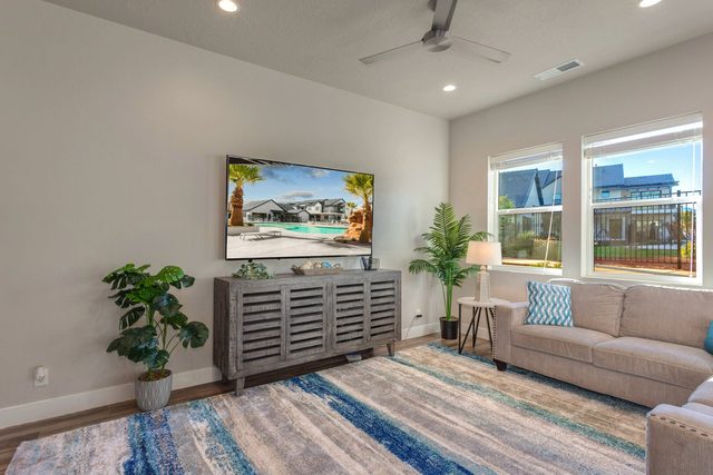 Living room with TV console, sofa and bright windows
