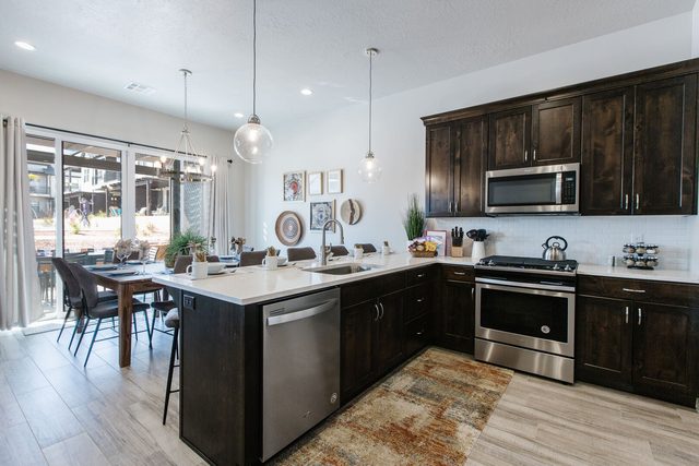 Kitchen with dark cabinets, stainless appliances and bar seating