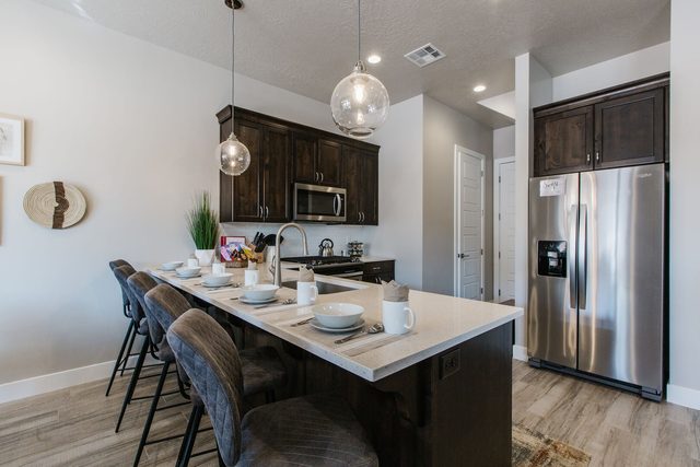 Kitchen peninsula with upholstered bar stools and stainless fridge