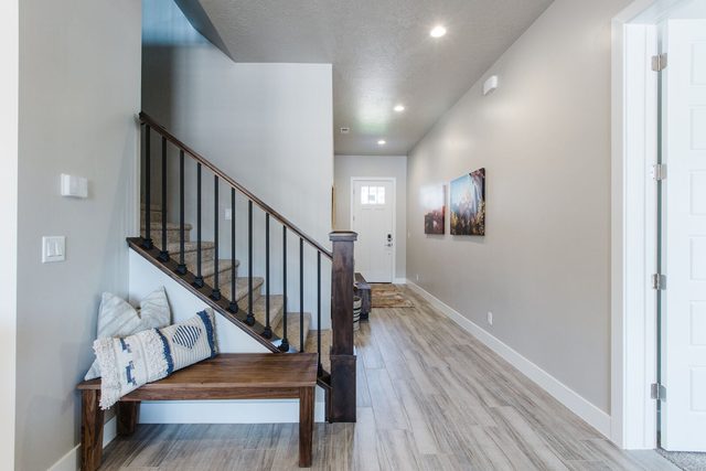 Entry hallway with staircase and wooden bench