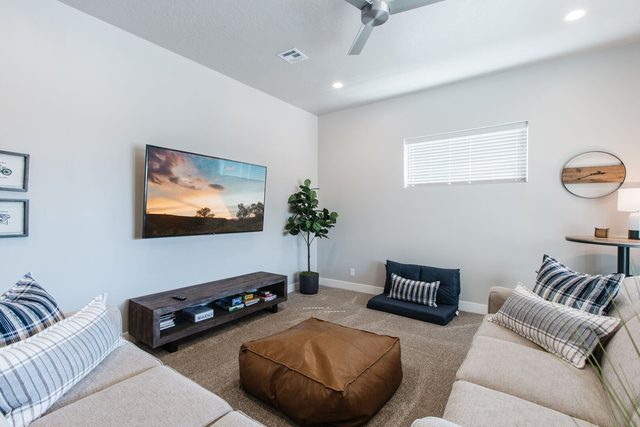 Loft lounge with sofas, leather pouf and TV
