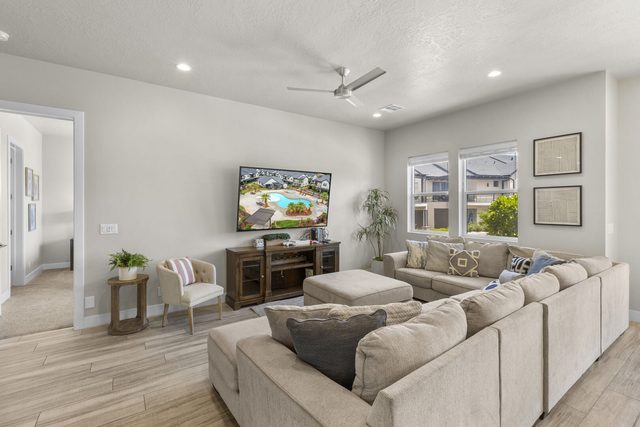 Great room with oversized sectional, ottoman and wall-mounted TV