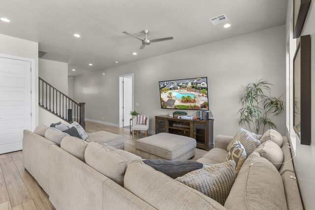Living room sectional facing the TV with staircase to upstairs