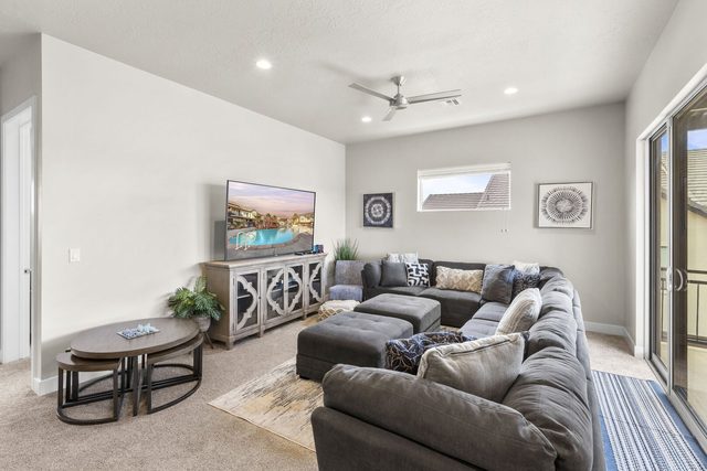 Loft lounge with gray sectional, ottomans and flat-screen TV