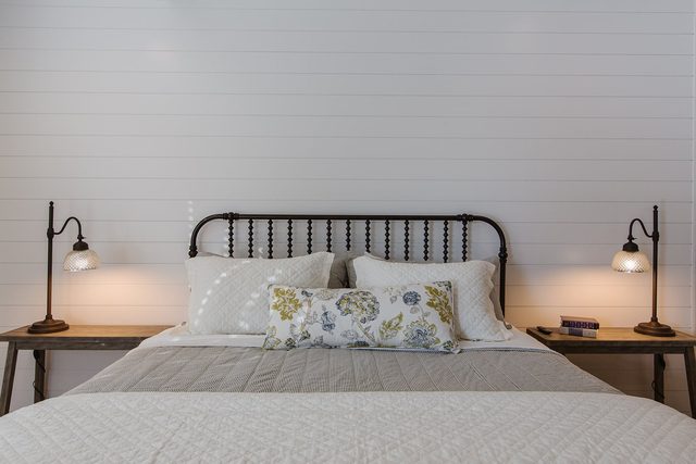 King bed with shiplap wall and bedside lamps in the master bedroom