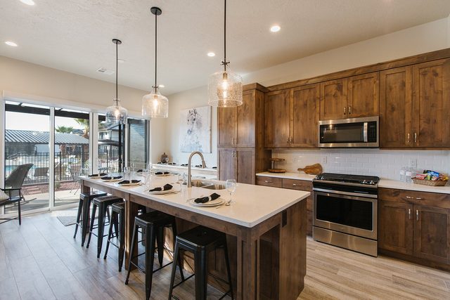 Kitchen island with bar stools beside sliding patio doors