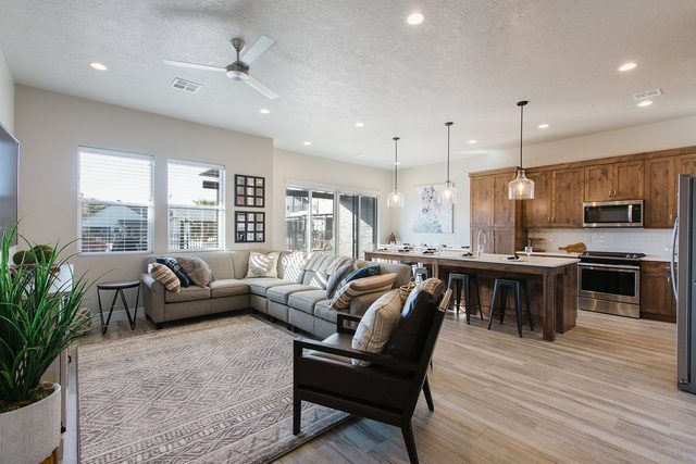 Open living room with sectional sofa flowing into the kitchen