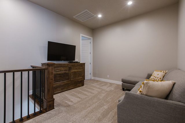 Upstairs loft lounge with sofa and TV on a wood cabinet