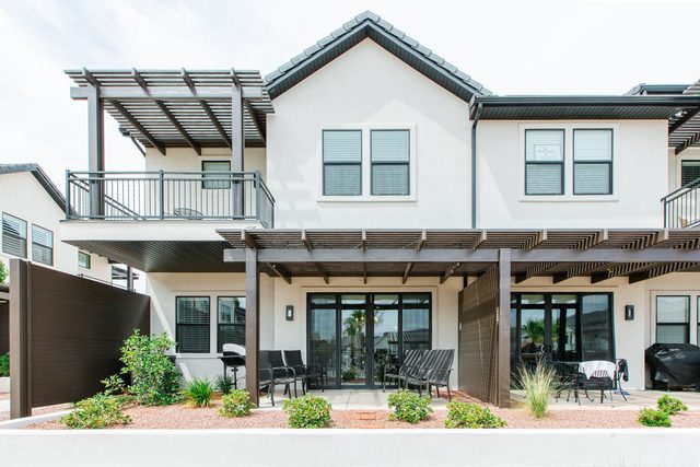 Back exterior with private patio, pergola and upstairs balcony