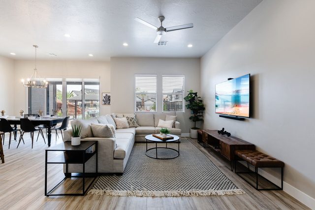 Open living room with sectional, smart TV and dining area at Ocotillo Springs 27