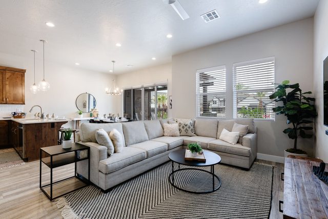 Living room sectional and round coffee table beside the kitchen
