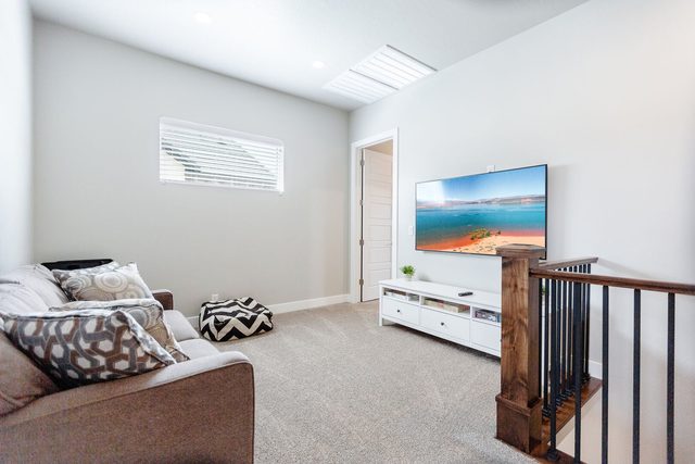Upstairs loft with sofa, TV and stair railing