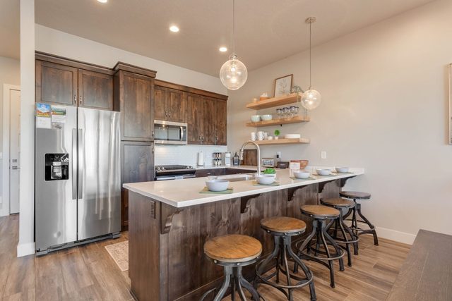 Kitchen island with four bar stools and stainless refrigerator