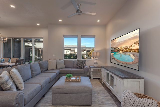 Living room sectional and ottoman facing a wall-mounted TV