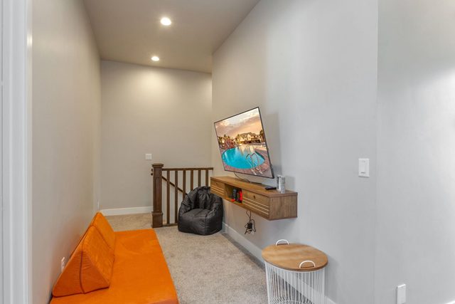 Upstairs loft with floor seating and wall-mounted TV