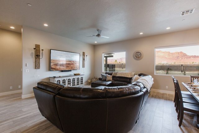 Curved leather sectional facing the wall-mounted TV at Ocotillo Springs 32