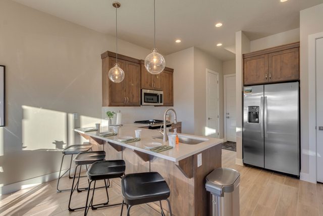 Kitchen island with bar stools and stainless steel refrigerator