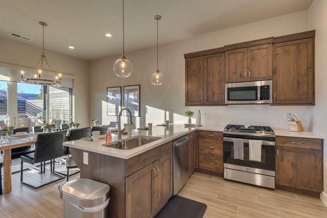 Kitchen with gas range, pendant lights and dining area beyond