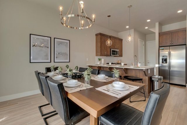 Dining table with seating for eight beneath a modern chandelier