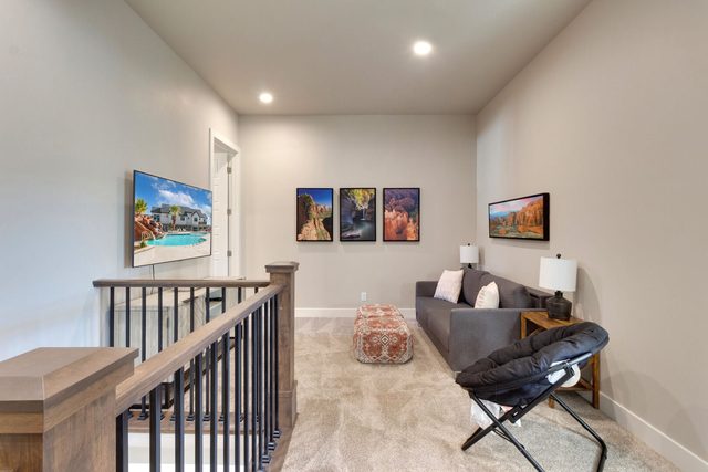 Upstairs loft with sofa and TV beside the stair railing