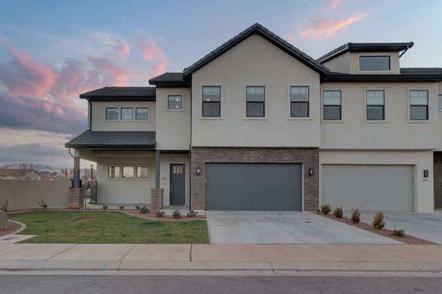 Front exterior of Ocotillo Springs 42 with two-car garage at sunset
