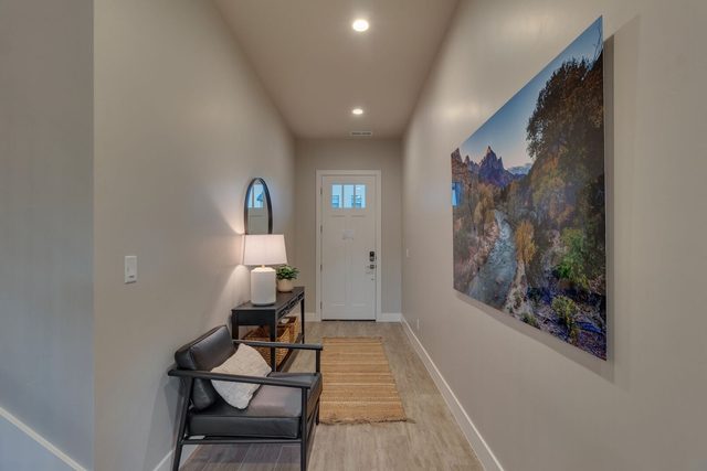 Front entry hallway with chair and landscape artwork