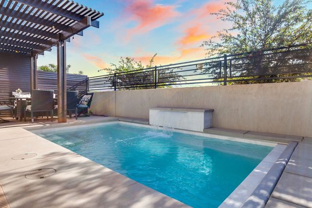 Private pool with waterfall and pergola at sunset