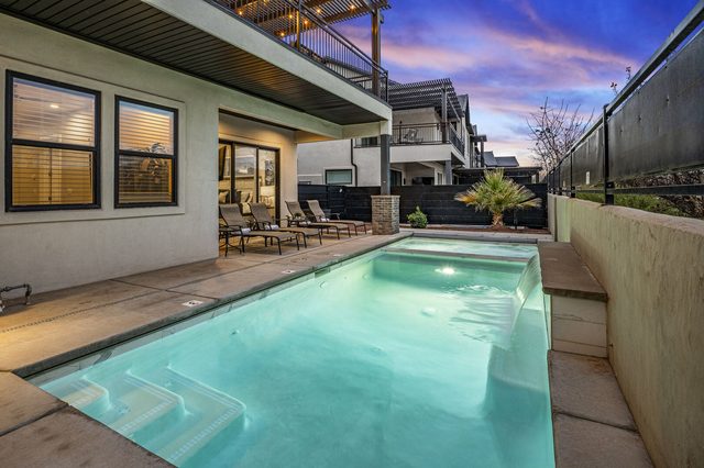 Private pool with built-in hot tub at dusk