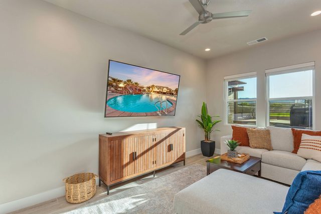 Living room with wall-mounted smart TV and wood media console