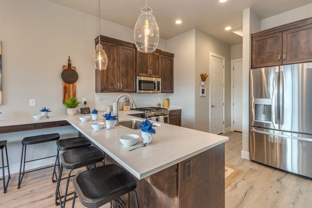 Kitchen island with bar stools and stainless refrigerator