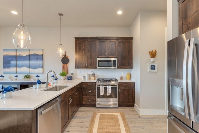 Kitchen with gas range, microwave and quartz counters