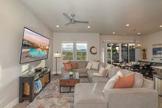 Living room sectional and smart TV open to the dining area