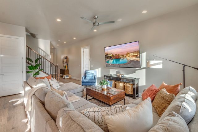 Large sectional sofa facing the TV with stairs beyond