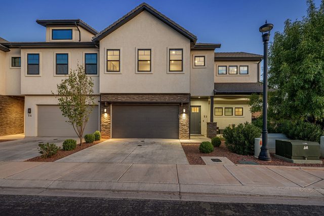 Front exterior and garage of Ocotillo Springs 53 at dusk