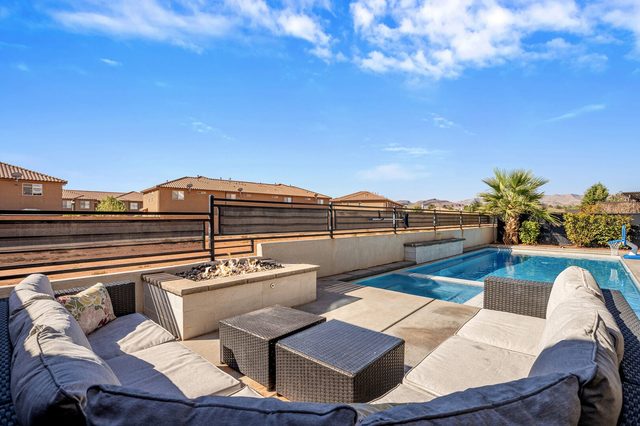 Poolside fire pit lounge with cushioned sofas and hot tub