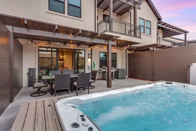 Swim spa in front of the covered patio and outdoor dining table