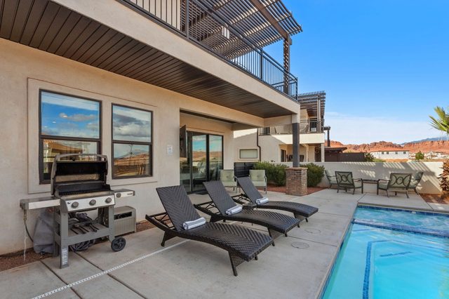 Gas grill and lounge chairs along the private pool
