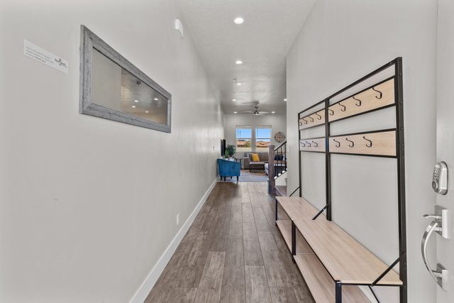 Entry hallway with bench and coat hooks leading to living area