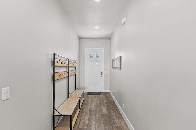 Entry hallway with bench and hooks looking toward the front door