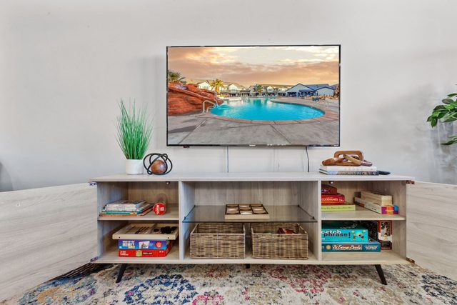 TV console stocked with board games and a game system