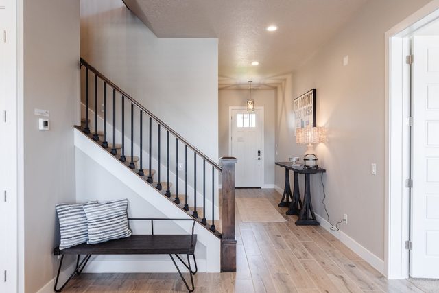 Entry hallway with staircase and bench near the front door