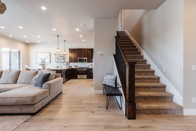 Open main floor with sectional sofa, staircase and kitchen beyond