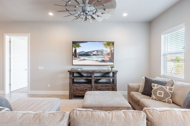 Living room seating with ottoman and wall-mounted TV